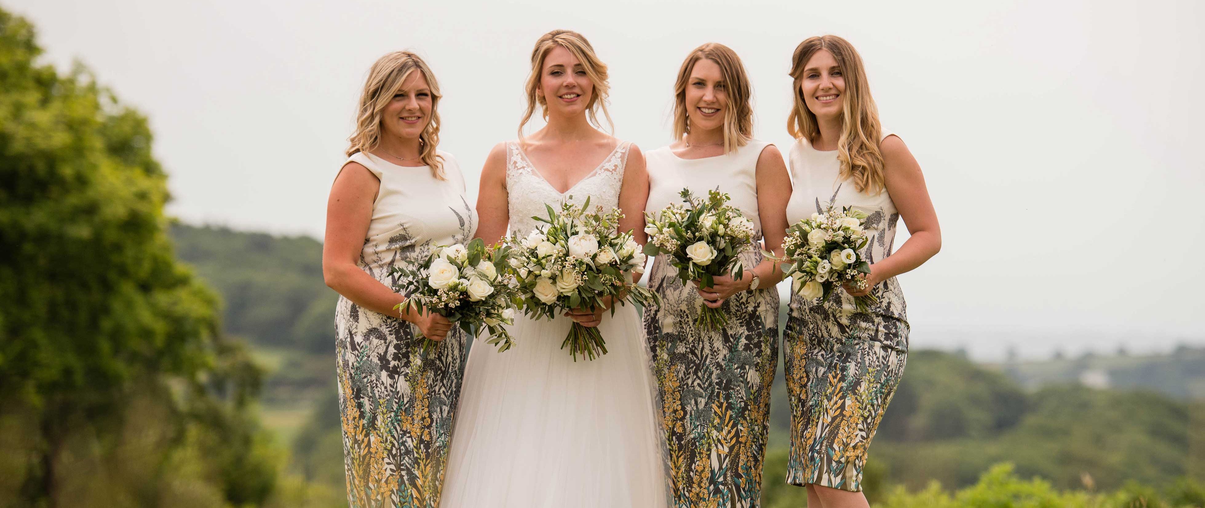 Bride and bridesmaid standing together with bouquets