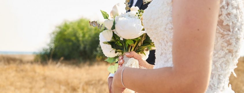 bride holding a bouquet of white peonies