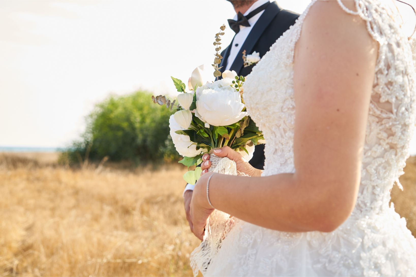 bride holding a bouquet of white peonies