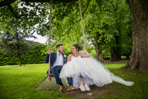 Bride and groom playing on the swing at Soughton Hall