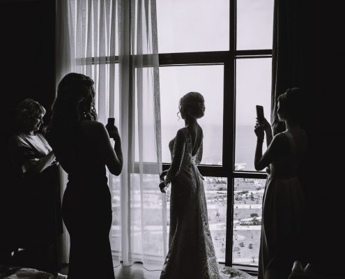 Bridesmaids taking a photo of the bride on her wedding day