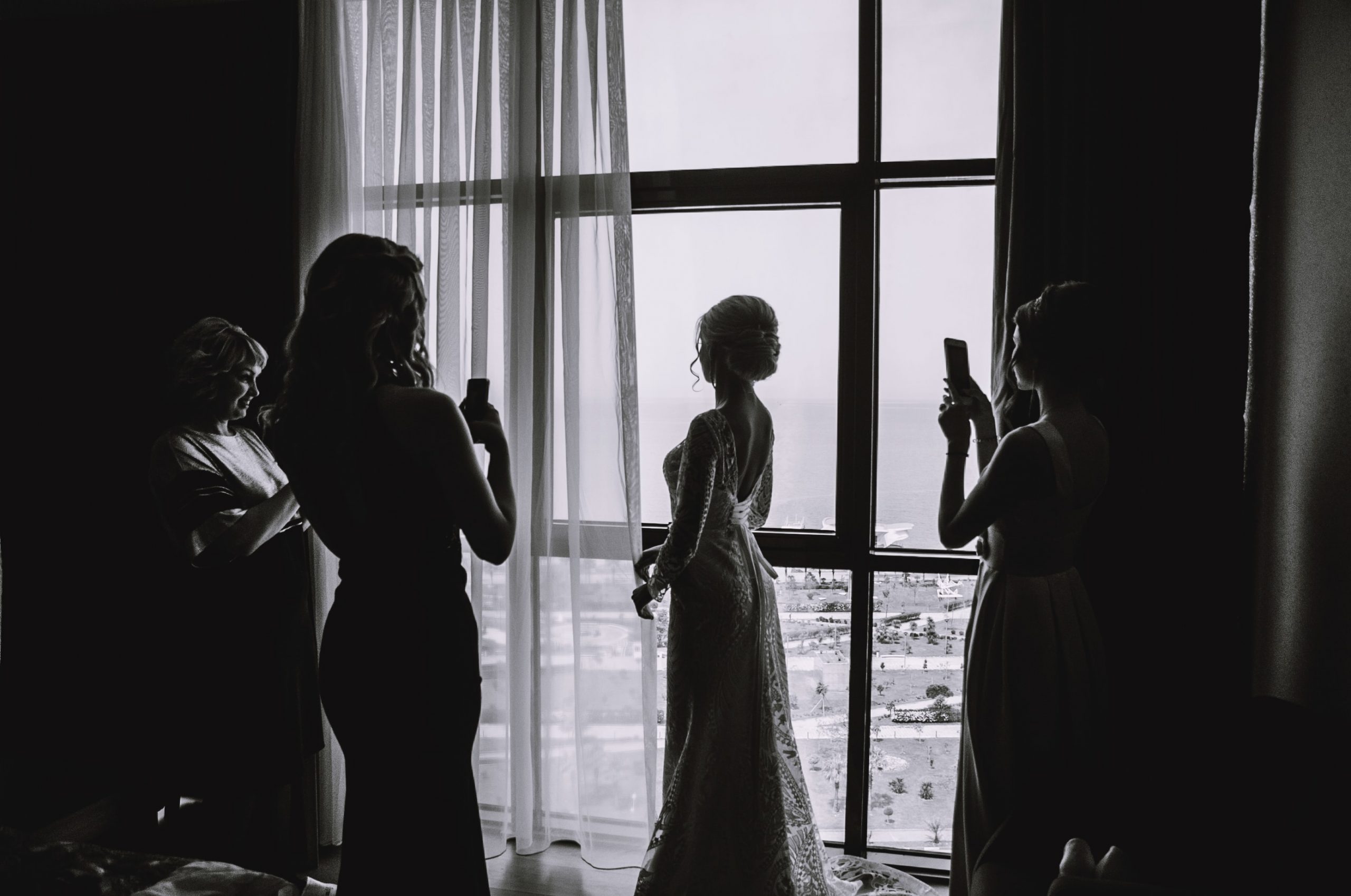 Bridesmaids taking a photo of the bride on her wedding day