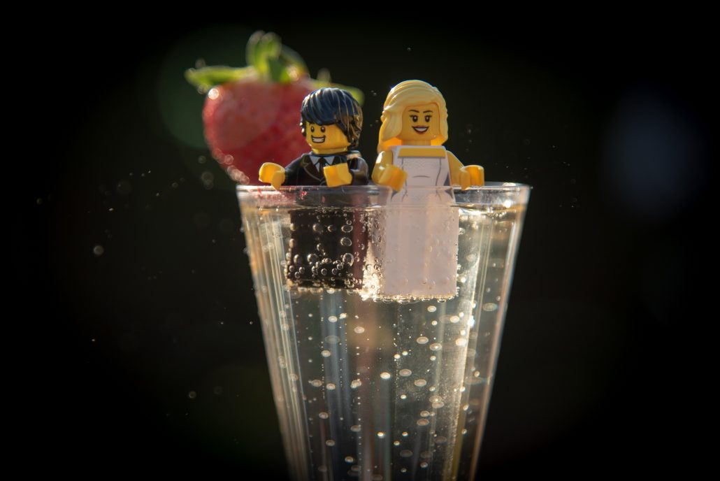 Lego wedding couple sitting in a glass of prosecco