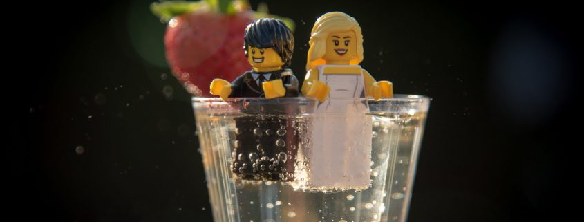 Lego wedding couple sitting in a glass of prosecco