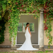 The bride standing under an arch of flowers