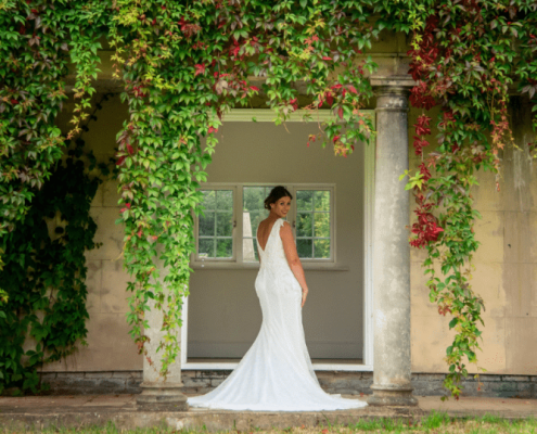 The bride standing under an arch of flowers