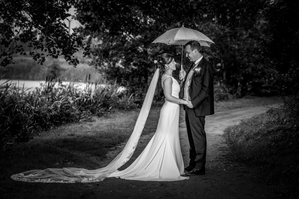 Bride and groom for Shropshire wedding under an umbrella