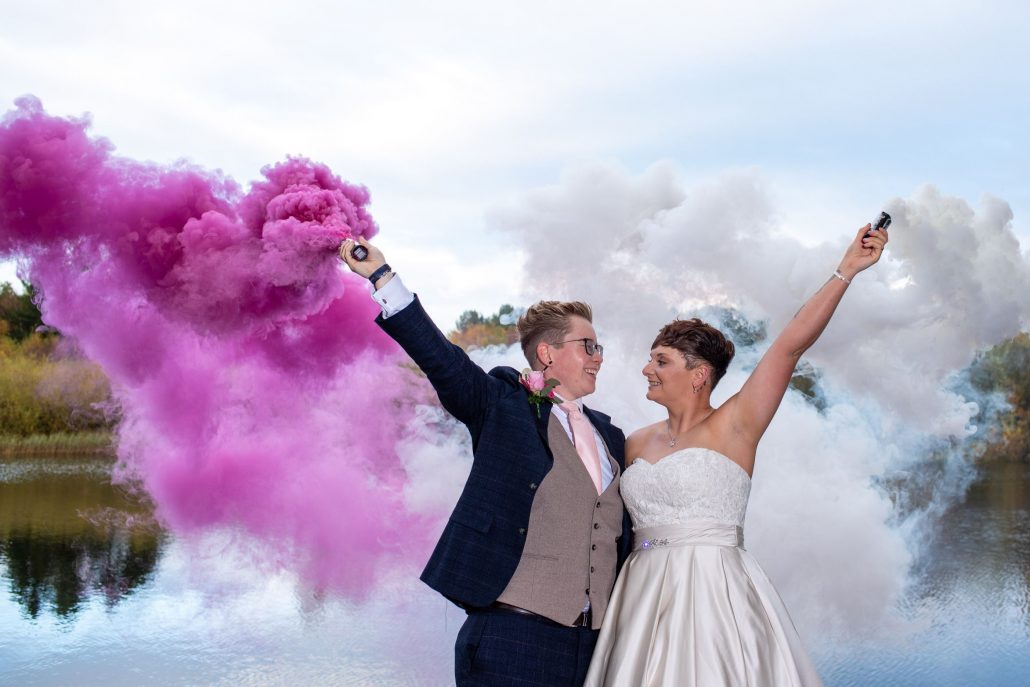 The bride and bride using coloured smoke bombs for their wedding photos